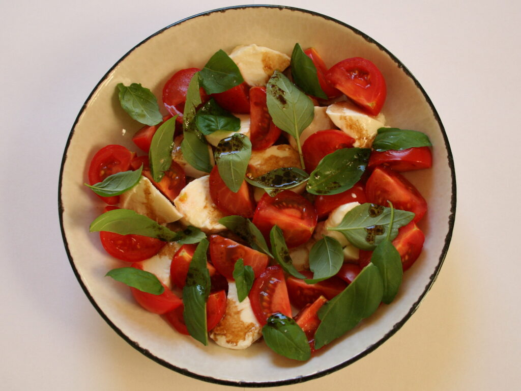 A bowl of caprese salad with balsamic vinegar